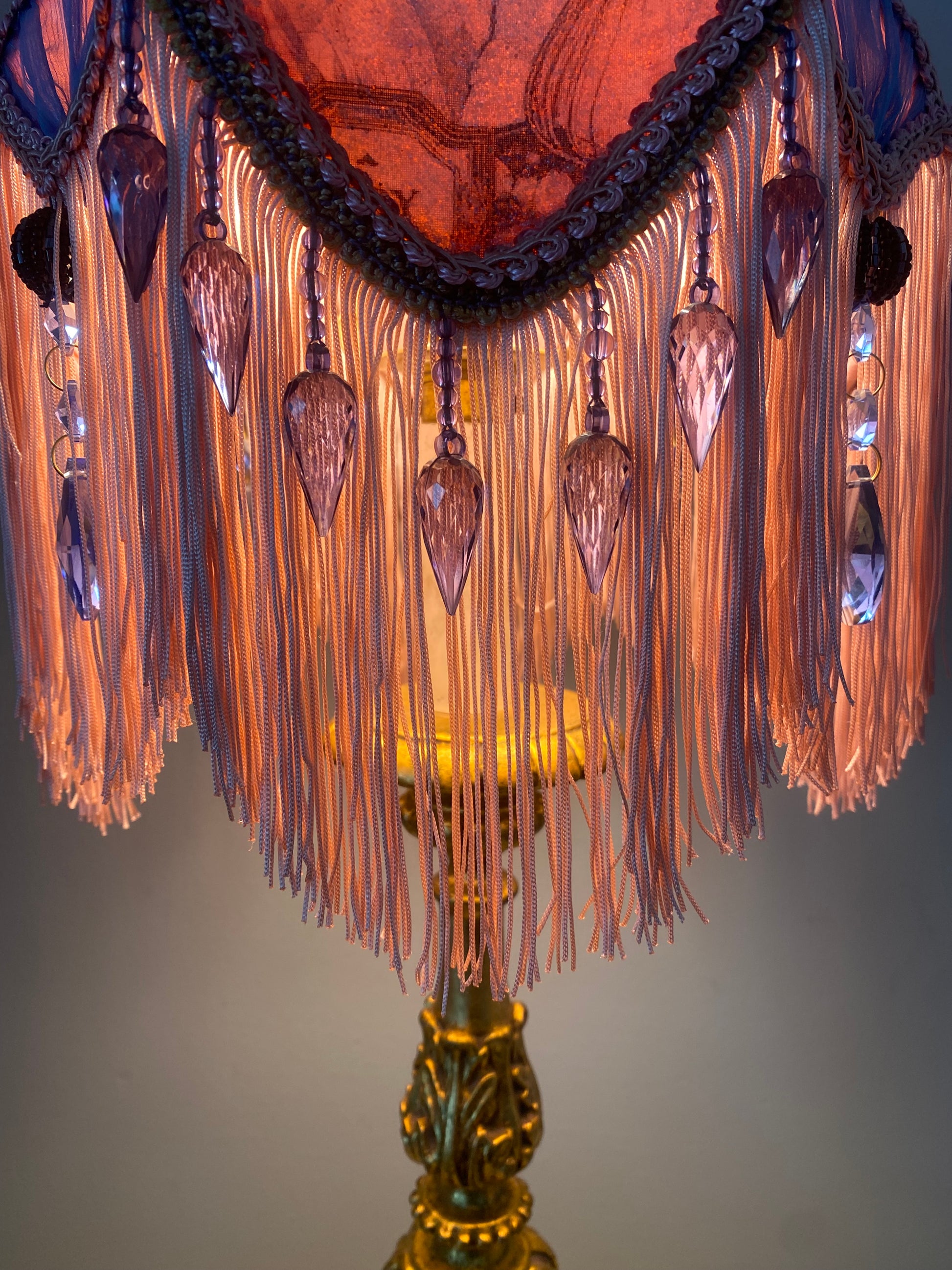 Close-up of fringe detail – “Soft pink fringe and blue glass beaded trim cascading from the edge of a Victorian tulip lampshade – antique-inspired vintage lighting accent.”