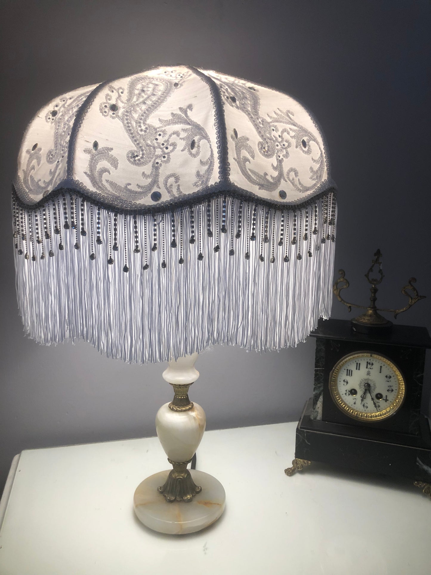 Lifestyle shot – lit lamp (room setting)
“Victorian white silk fringe lampshade illuminated in a vintage-style room, with lace and diamante details casting a warm, elegant glow.”
